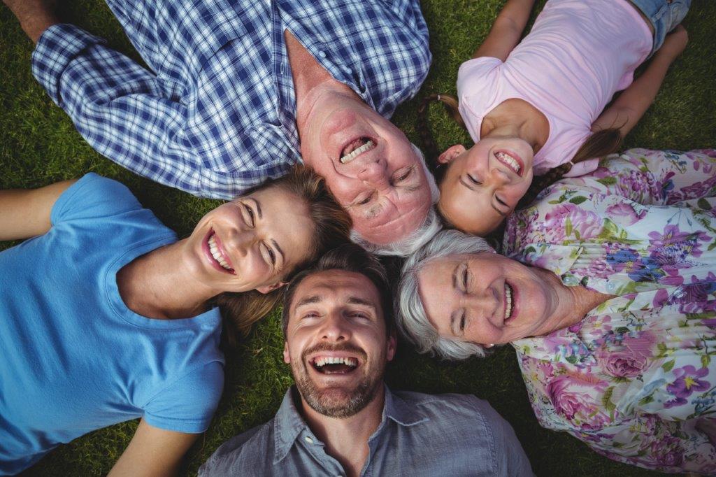 Mehrere Generationen Abbildung von Personen verschiedenen Alters, die im Gras liegen