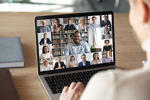 Abbildung einer Videokonferenz. Auf einem Monitor sind verschiedene Teilnehmende einer Videokonferenz zu sehen.
